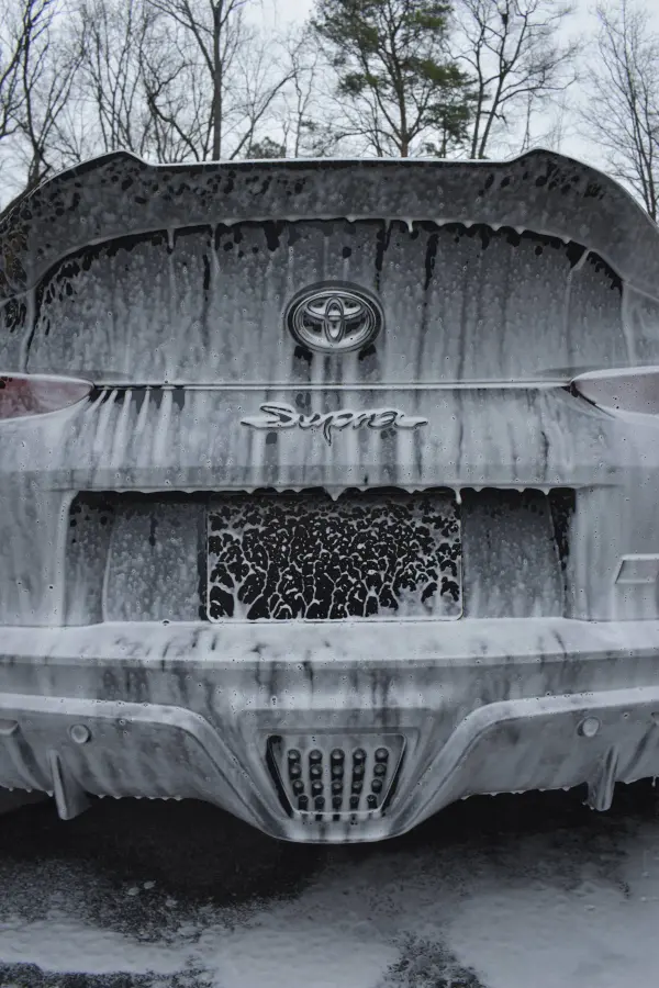Toyota Supra under a thick blanket of snow foam